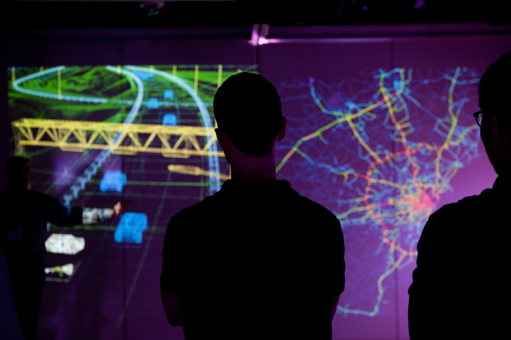 figure silhouetted in front of projected traffic data simulation