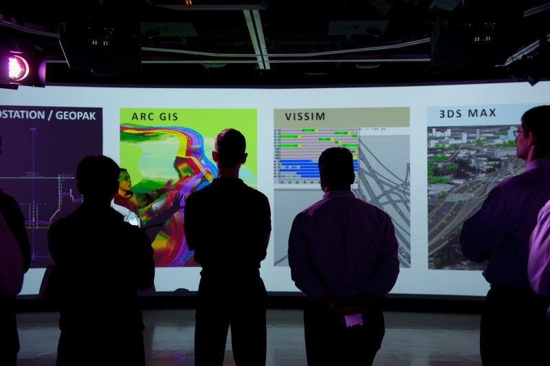 Silhouetted figures view projected data on ARC GIS, VISSIM, and more