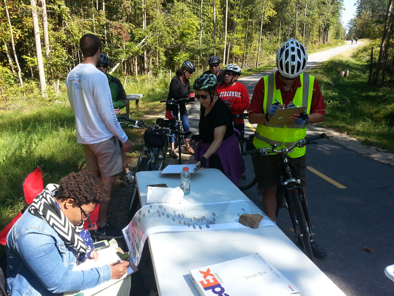 Volunteers and cyclists gathered around data monitoring table