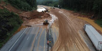 A multi-lane highway is blocked with mud and debris